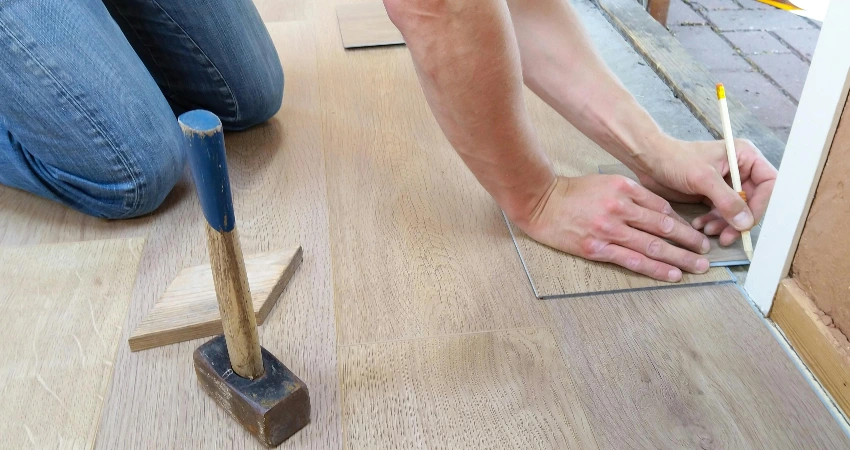 Person installing vinyl plank flooring on their garage floor