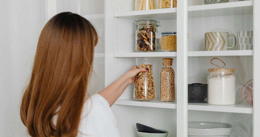 Woman reaching for a jar in the pantry