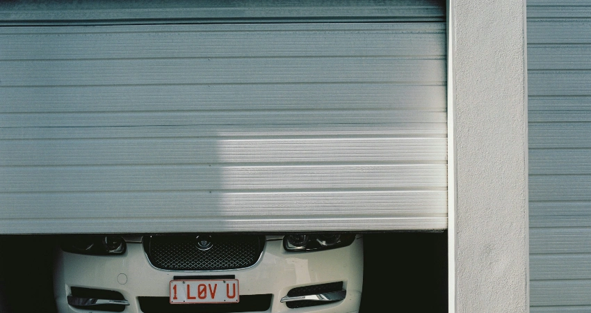 black and silver car in front of garage door