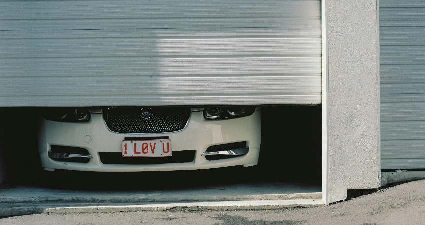 black and white car in front of garage door