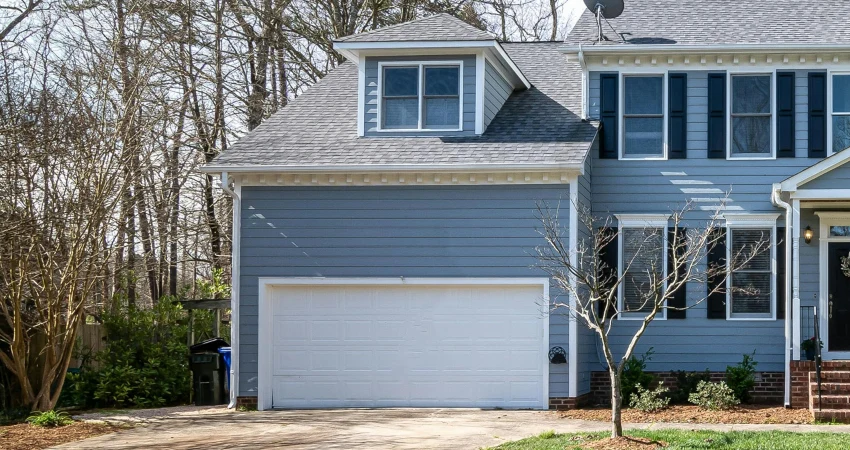 blue house with white garage door and garage door sensors