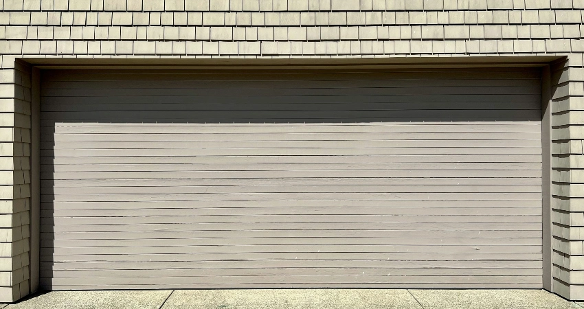 damaged garage door shows visible signs of wear, indicating it may require repairs