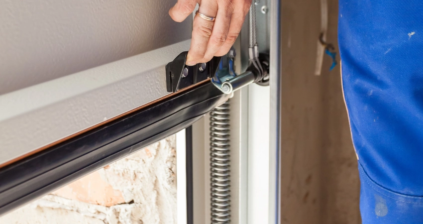 garage door repair man checking weatherstripping