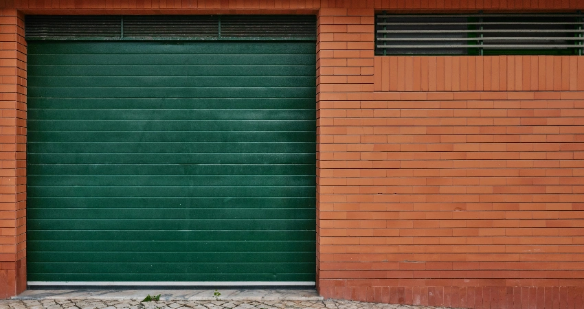 green garage door on a brick building