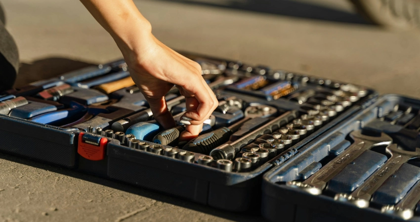 person grabbing a tool from toolbox
