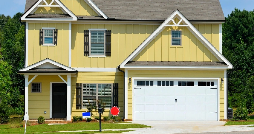 yellow house with white garage door that costs money